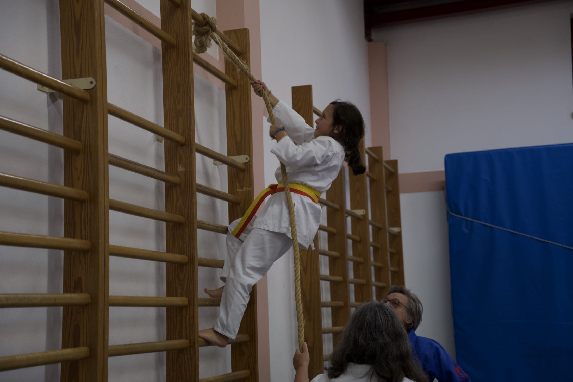 Jovem praticante a subir uma corda durante o treino