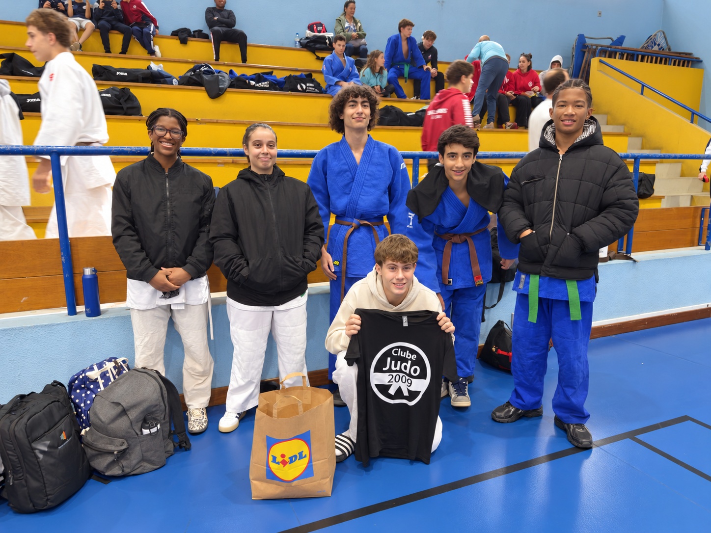 Seis judocas do Clube de Judo 2009 reunidos no pavilhão, um deles a apresentar uma camisola com o emblema do clube